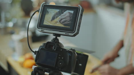 primer plano de la pantalla de la cámara grabando al chef cortando ajo