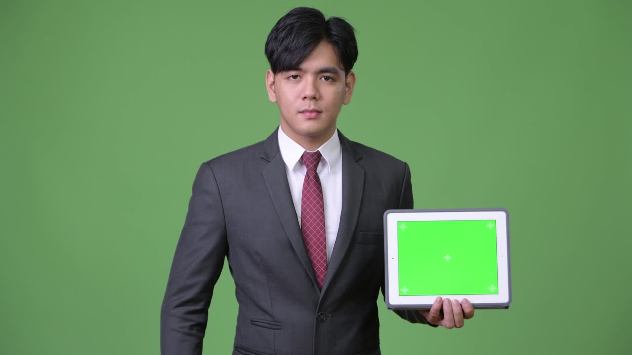 디지털 태블릿을 사용하는 젊은 잘생긴 아시아 사업가