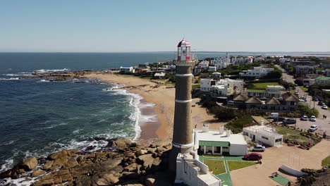 Drone-circling-around-lighthouse-on-rocks-above-ocean