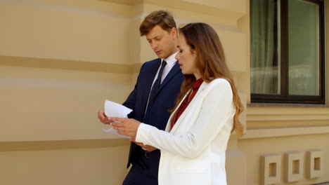 closeup couple discussing documents . man and woman smiling with papers outside