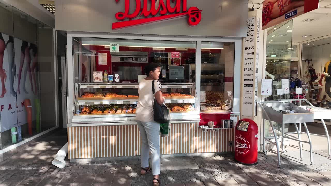 Bakery, small vendor in Darmstadt with buyer in front. Normal everyday life scene. Hessen, Germany