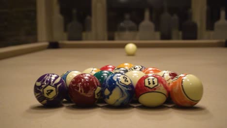 billiards table with pool ques and balls