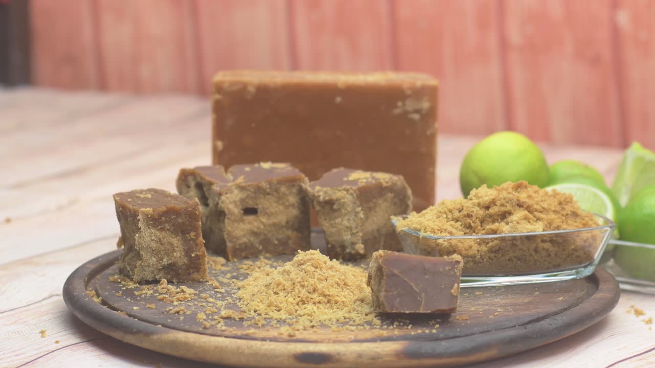 전통적인 요리 과정의 필수적인 첫 단계인 소박한 표면에 간 미정제 설탕(파넬라) 조각의 디테일 샷이에요