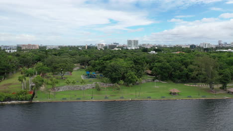 cloud daytime drone dolly over the public park with view of city over the ocean cinematic 4k