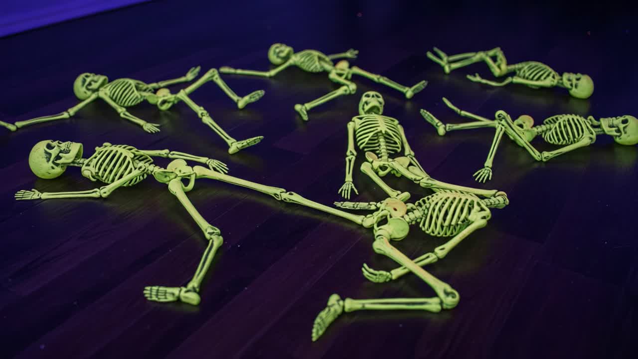 A Spooky Gathering: A Closer Look at the Glow-in-the-Dark Skeletons Creating a Whimsical Scene on a Dark Surface