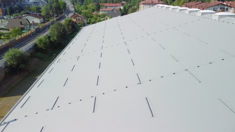 Flying-over-big-rooftop-insulated-with-panels-with-some-pigeons-flying-over-it