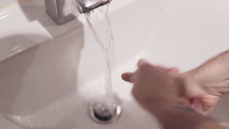 hombre lavándose las manos en el baño