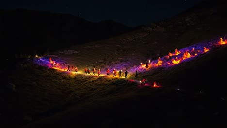 a nighttime expedition: enthusiastic hikers illuminate the mountain trail with vibrant lights under a starry sky in a captivating display of adventure and camaraderie