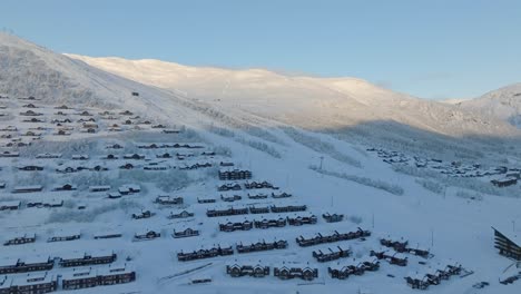 beautiful high end alpine skiing slopes in myrkdalen norway - aerial showing hillside between hotel and leisure homes nearby