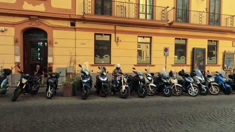 tourists and scooters on a bustling naples street