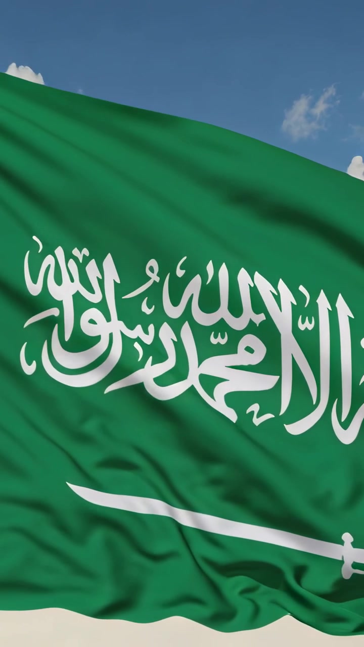 Video verticale: Bandiera saudita che sventola nella brezza contro il cielo blu, mostrando la shahada bianca e la spada