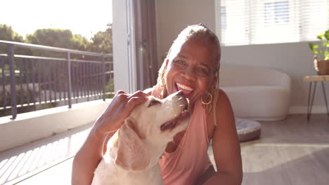 eine ältere afroamerikanische frau, die eine schüssel mit hundefutter hält