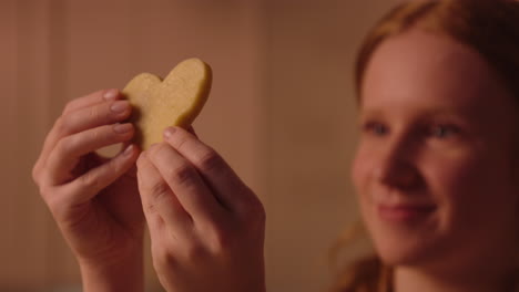 girl holding a heart shaped cookie