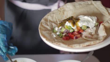 Chef-Agregando-Salsa-A-La-Comida-En-Un-Sabroso-Plato-De-Pan-Plano