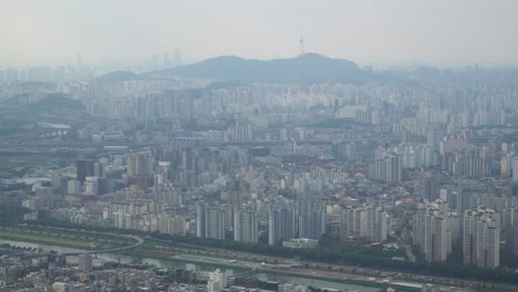 descripción general del horizonte de seúl en la niebla desde el pico de la montaña achasan con la torre n de seúl en la distancia