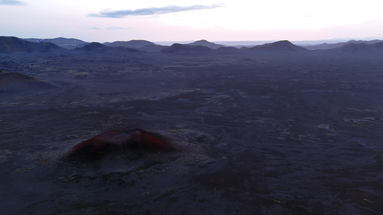 Cinematic aerial drone view of volcanic craters and lava fields in Iceland highlands, barren volcanic desert, rugged mountains and dramatic Nordic landscape, nature and geology background