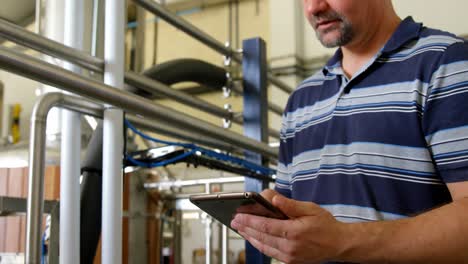 male worker using digital tablet in distillery 4k