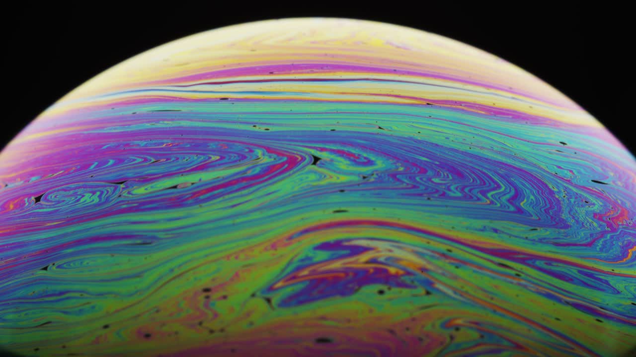 Colorful Hues Moving Downward in a Swirling Motion on Soap's Surface