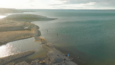 breathtaking aerial view of people enjoying lake strobel aka "jurassic lake" on a sunny day in argentina