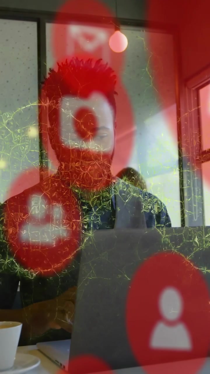 Vertical video: Man using laptop red tech icons popping web overlay touching face managing alerts