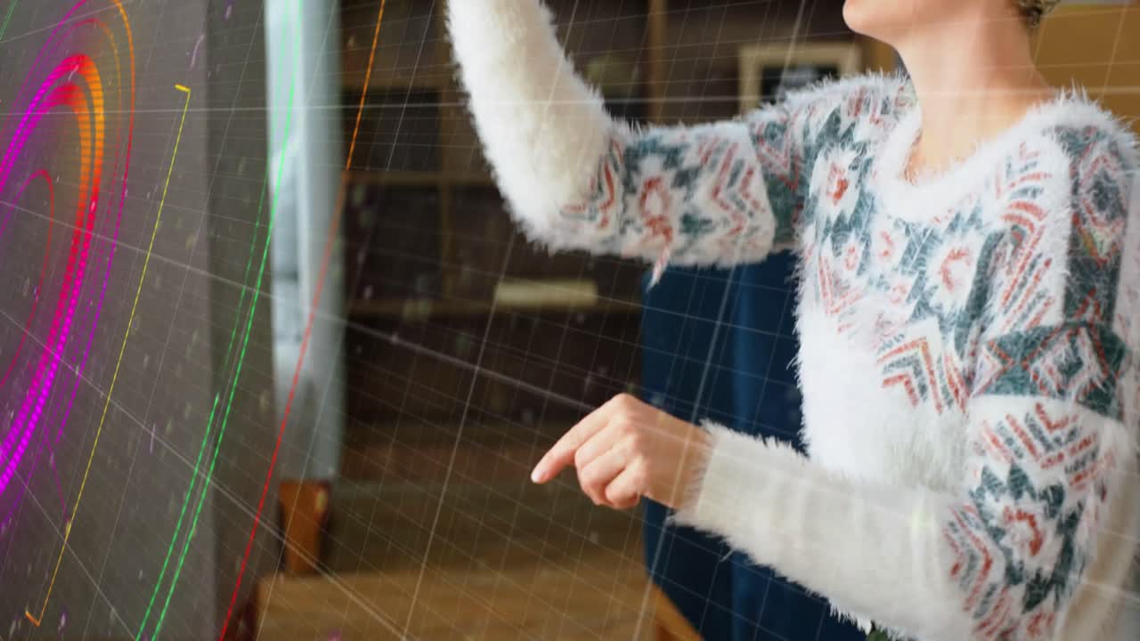 rastros de luz de neón sobre el escáner de alcance contra la mujer caucásica que usa auriculares vr en casa