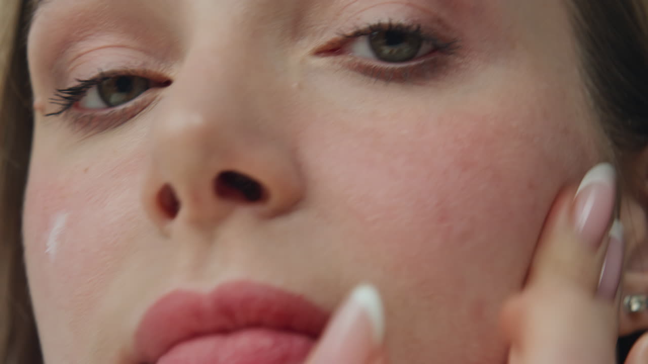 Close-up of a woman applying skincare product to her face