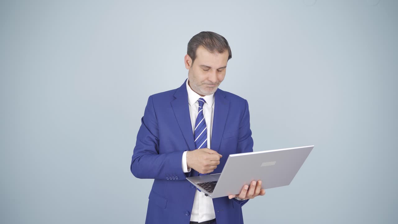 hombre de negocios mirando la computadora portátil con expresión cansada.