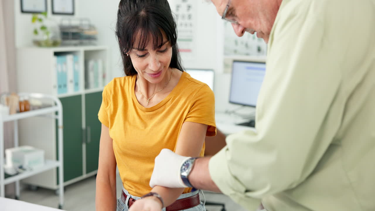 Doctor Applying Bandage to Woman's Arm in Medical Office