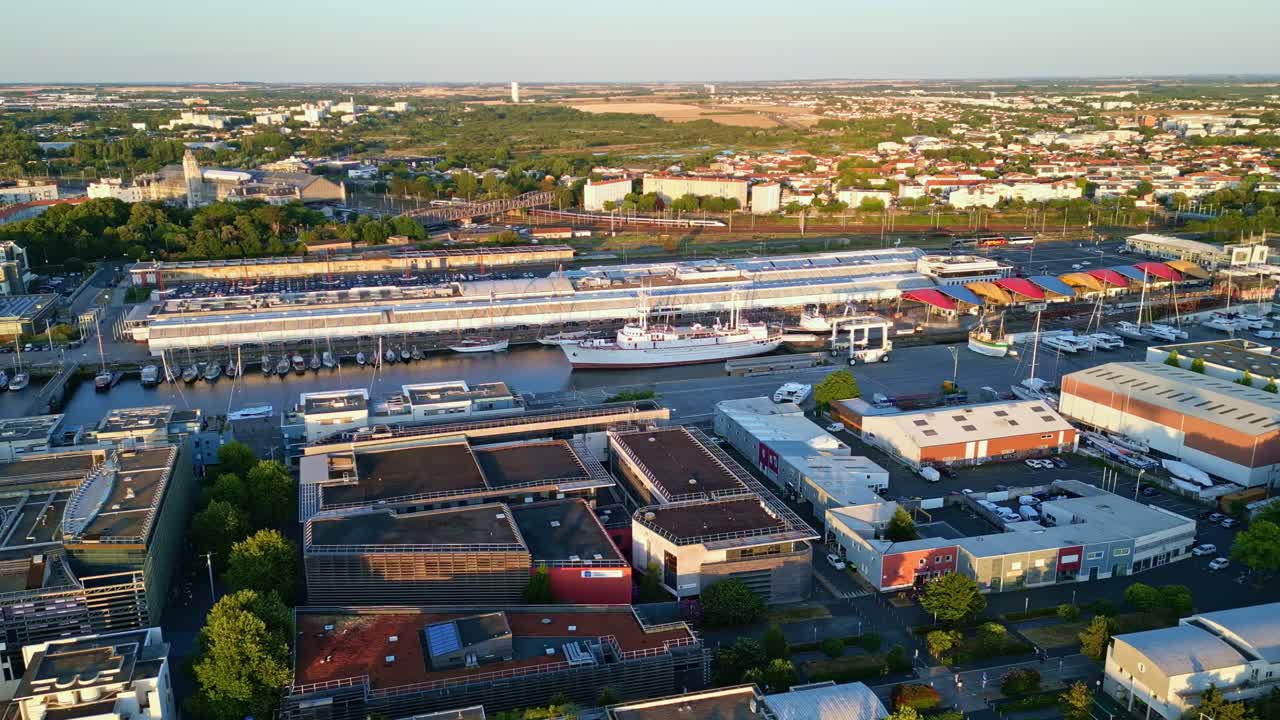 La Rochelle port at golden hour, Quai Louis Punier, maritime museum, boats, and cityscape, France. Aerial drone panoramic view