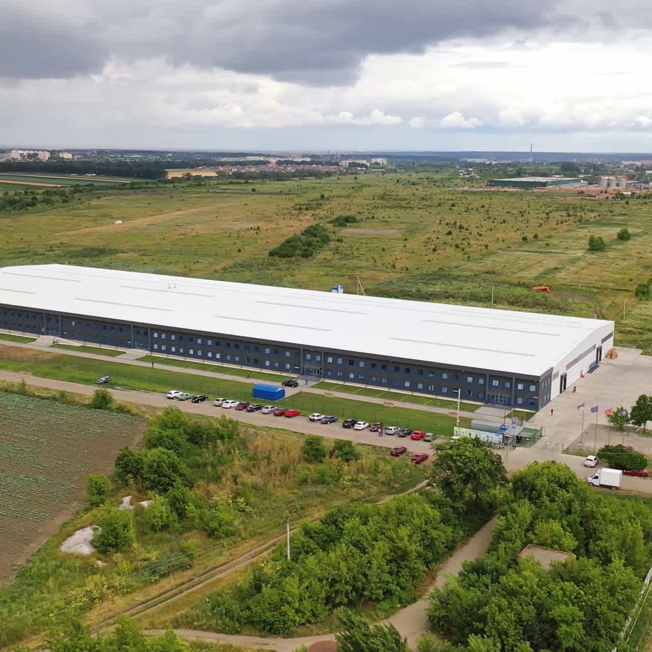 Modern industrial complex in the rural place. View from the air on commercial building in summer time. Aerial view.