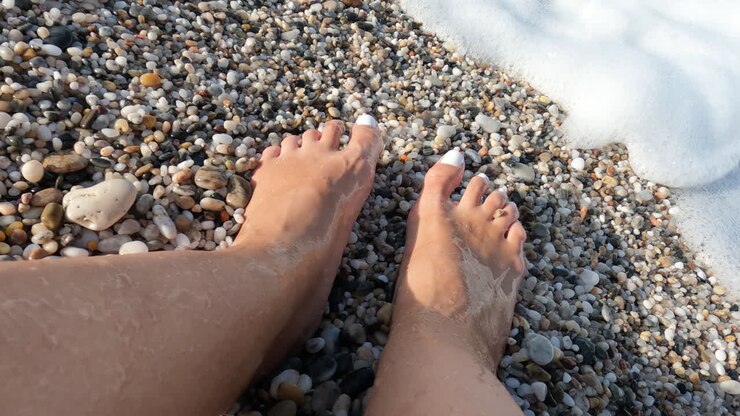 Piedi di donna nella schiuma del mare