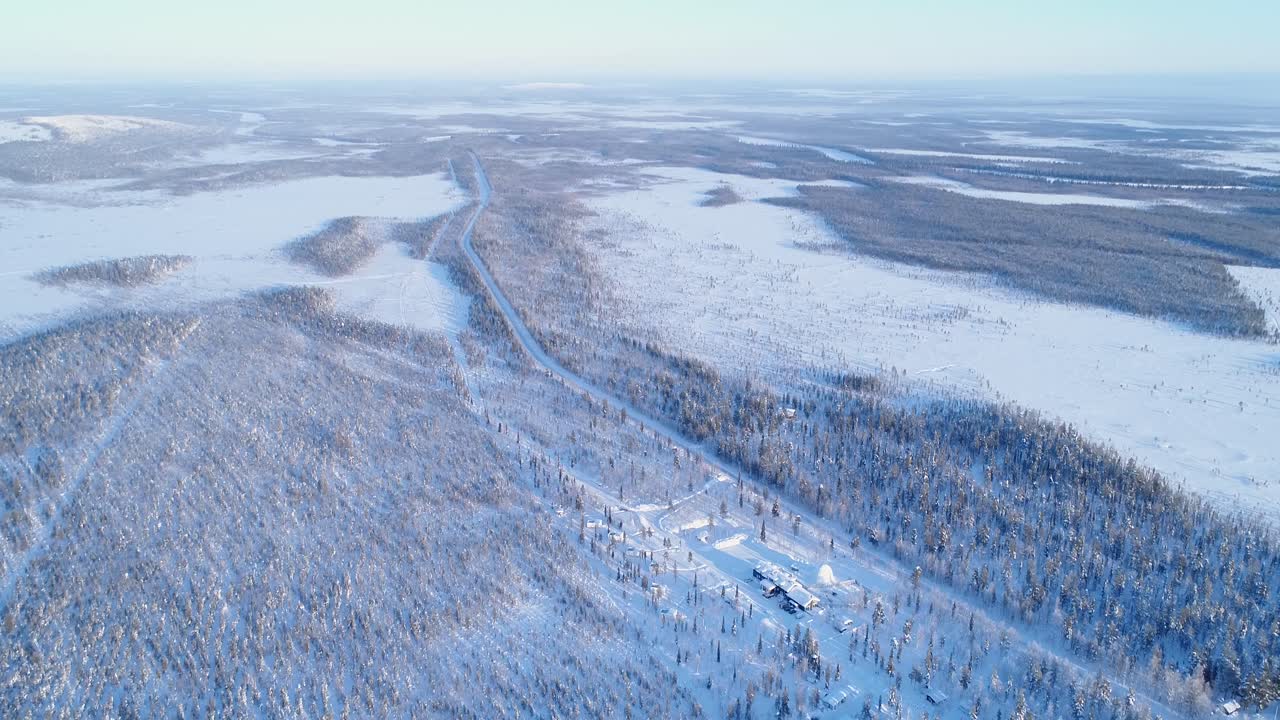 조감도는 콩가스 핀란드의 북극광 목장으로 이어지는 눈 덮인 풍경을 가로지르는 도로를 보여줍니다.