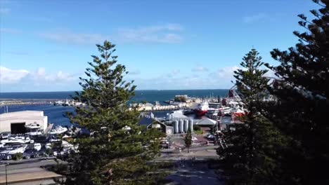 aerial view flying above trees in fremantle shot of ferris wheel in western australia with harbour