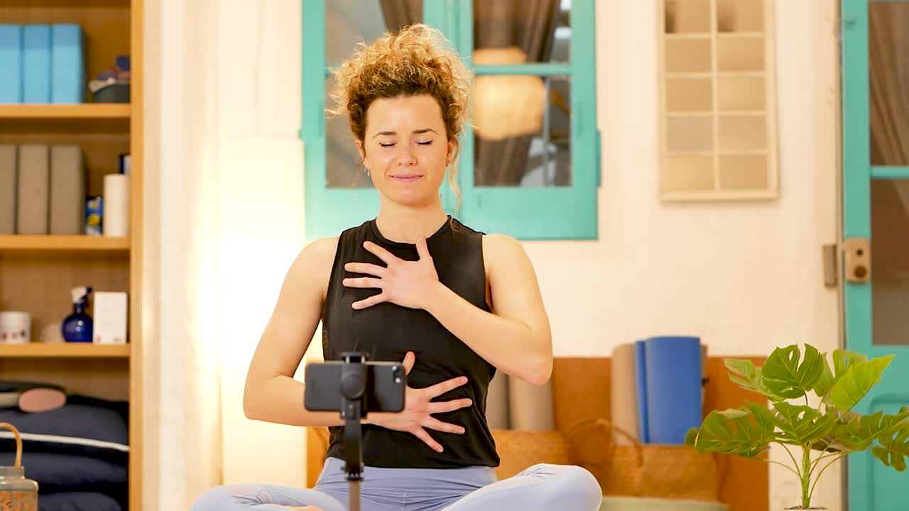 Cheerful woman performing breath works in Lotus pose at home