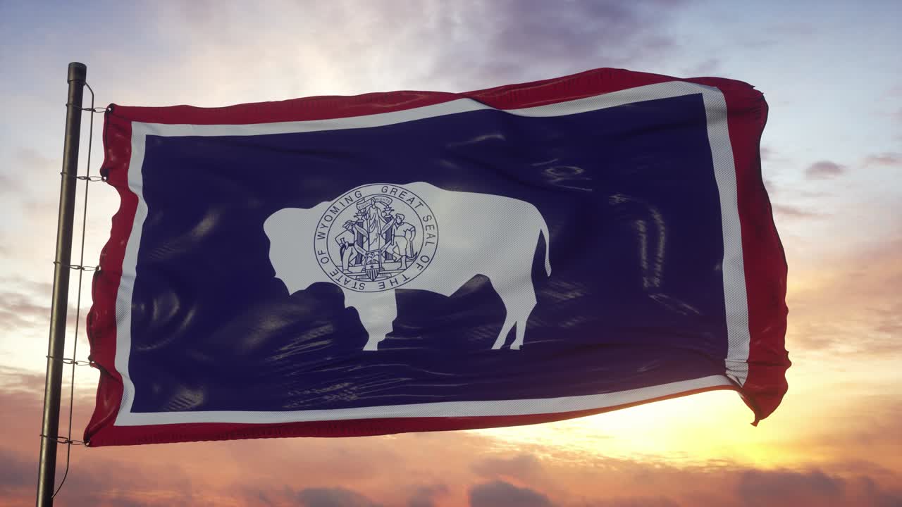 Bandeira de Wyoming tremulando ao vento contra um céu profundo e bonito ao pôr do sol.