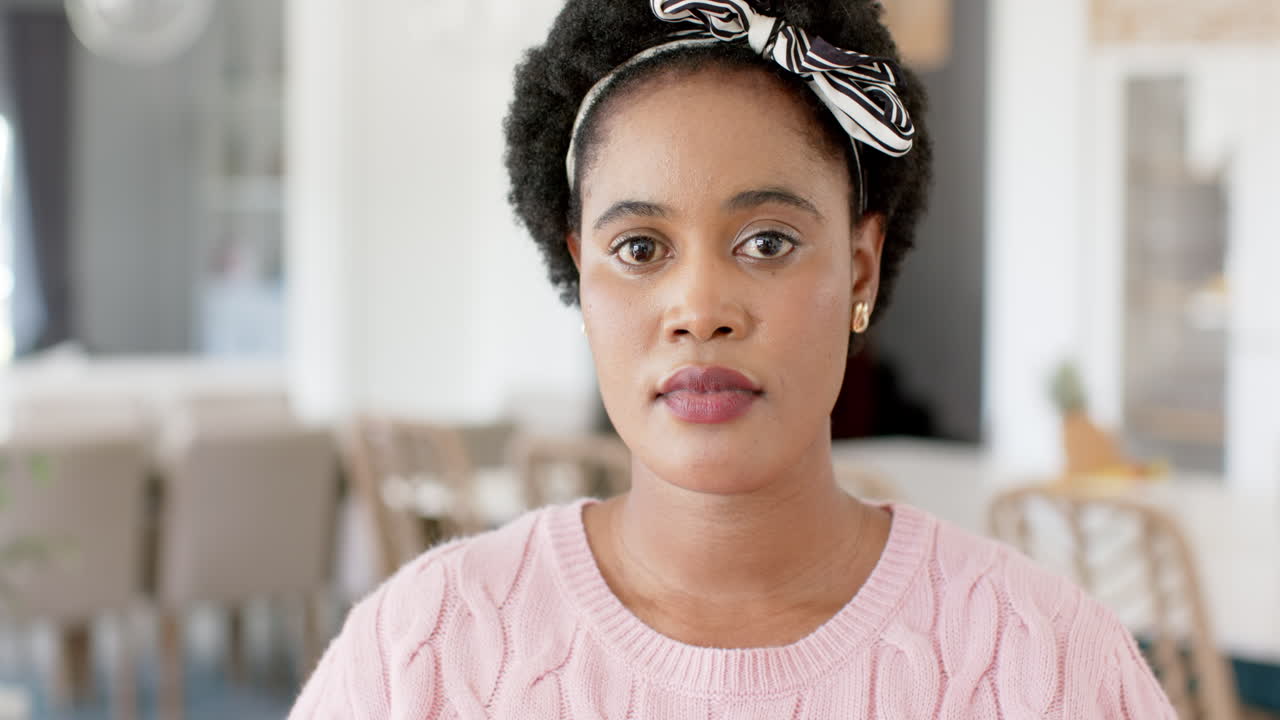 Donna afroamericana con un'espressione pensierosa a casa