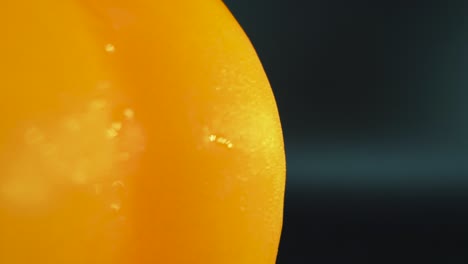 a macro close up detailed shot of a wet sweet yellow pepper on a 360 rotating stand, shiny sweaty water drops, cinematic studio lighting, slow motion, smooth movement, 4k video