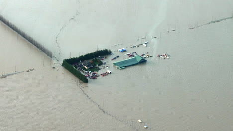 warehouse and vehicles submerged in flood after rainstorm in british columbia, canada