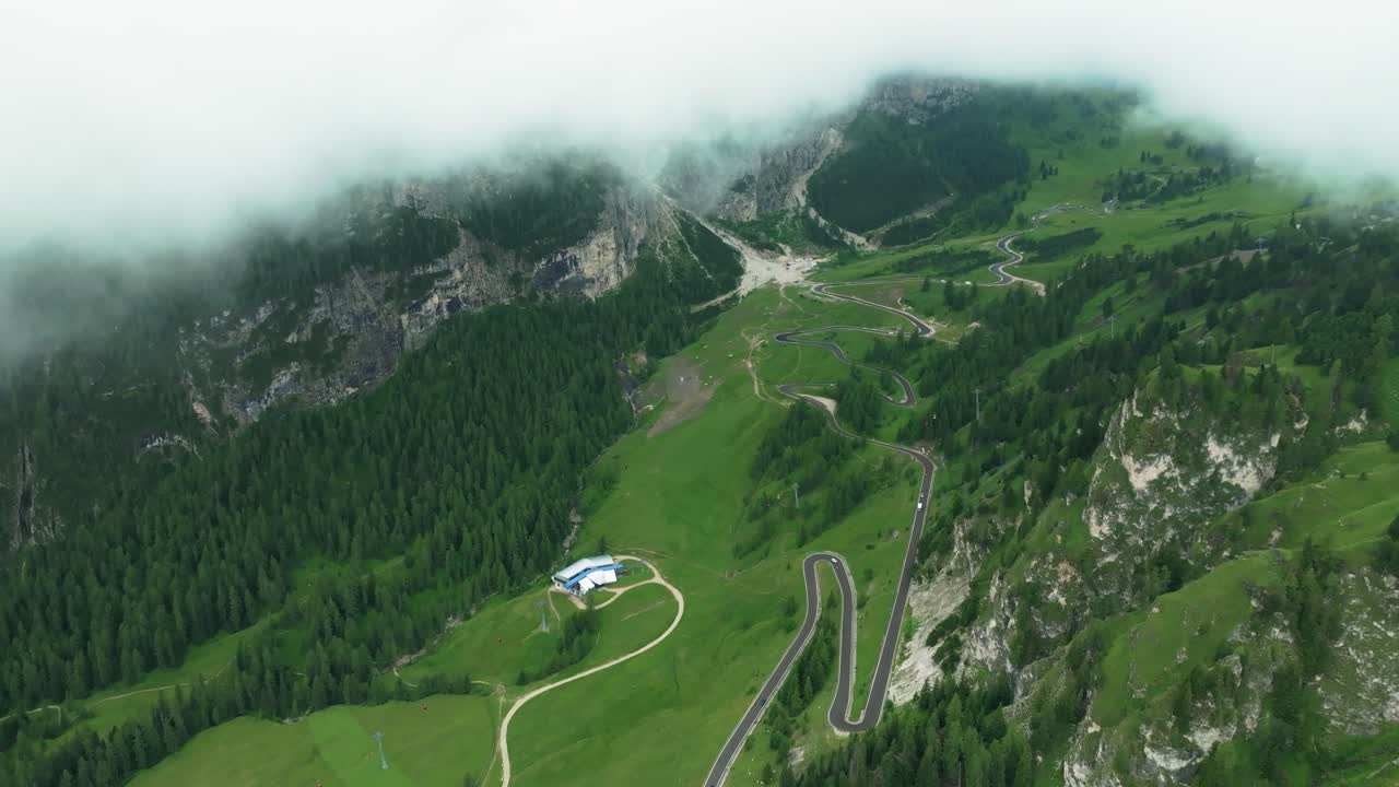 una vista aérea inclinada hacia abajo de la sinuosa carretera del paso de val gardena, dolomitas