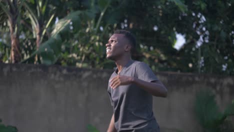 a slow motion shot of an african youth receiving a volley ball and deflecting it with his arm
