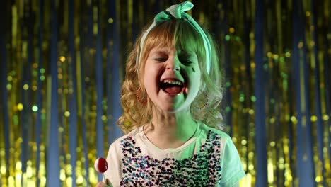 Child-kid-in-neon-lighting-posing-at-disco-party-cyberpunk-studio,-girl-making-faces,-fooling-around