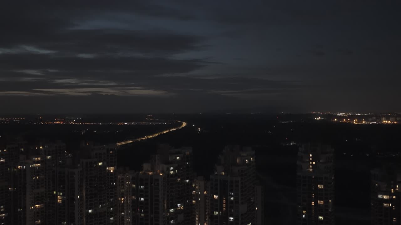 Aerial view of the residential buildings in Forest City, drone slowly ascending at night