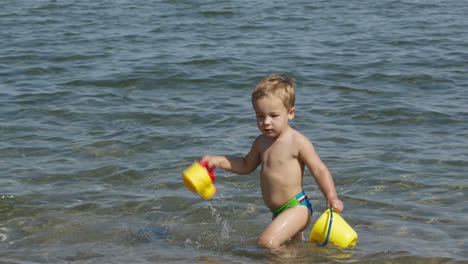 Entzückender-Kleiner-Junge,-Der-Im-Meer-Spielt