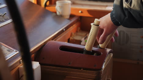 person's hand operating controls on a boat