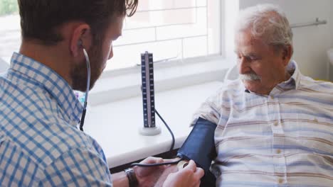 doctor examining a senior man in a retirement home