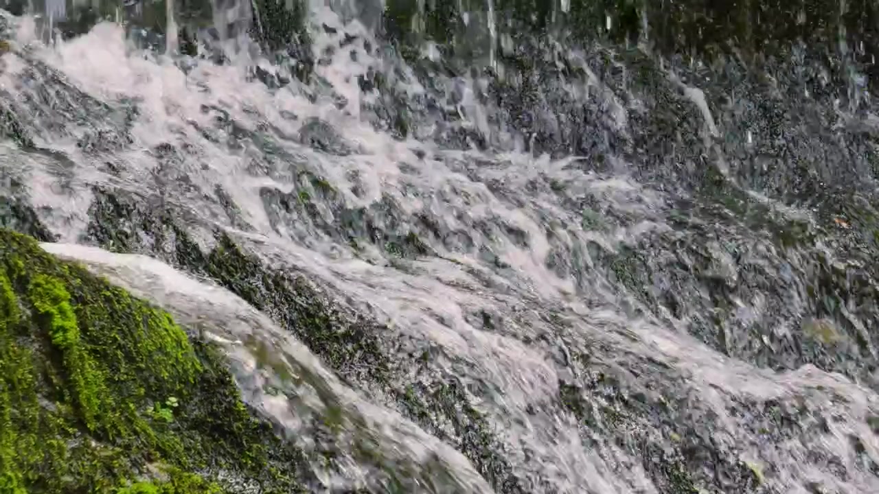 River Water Flowing Down and Cascading Across Mossy Rocks in Slow Motion 4K