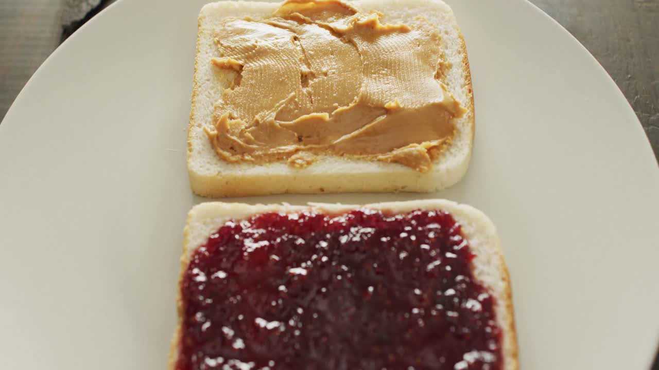 близкий вид арахисового масла и желе в тарелке на деревянной поверхности