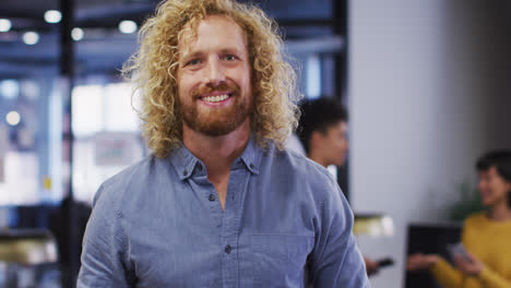 portrait of happy caucasian businessman looking at camera at office