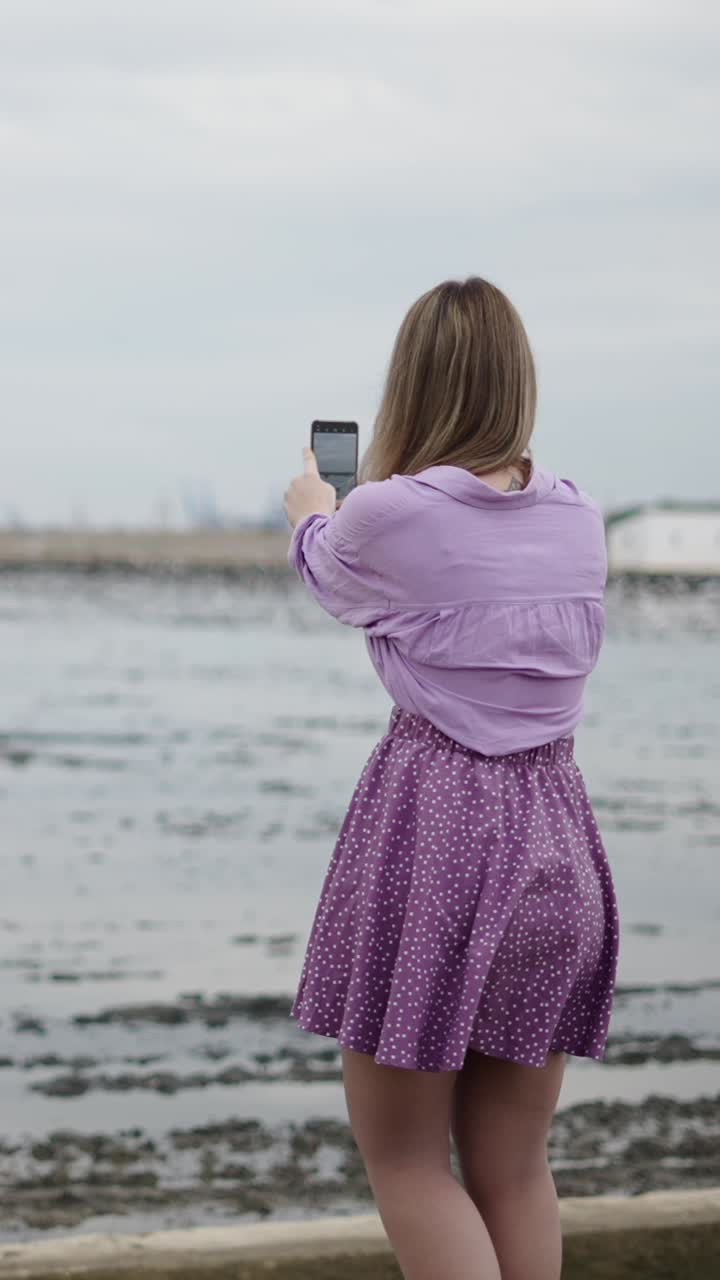 Woman in purple skirt by the sea
