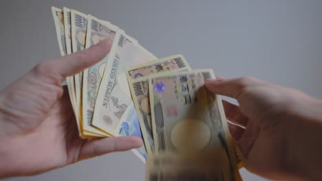 Shot-of-someone's-hands-holding-some-Japanese-currency